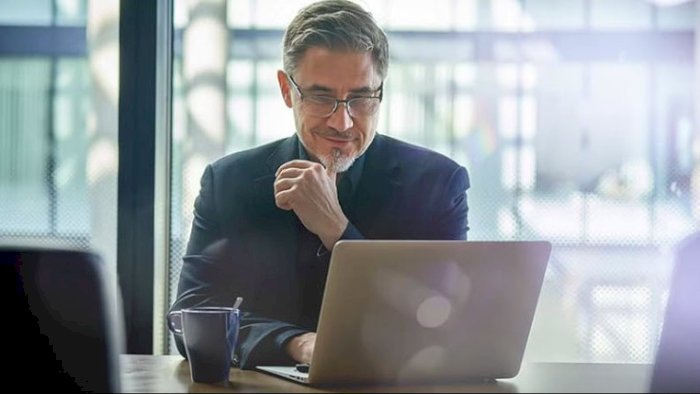 Mann ved PC som gjennomfører HMS-kurs for ledere