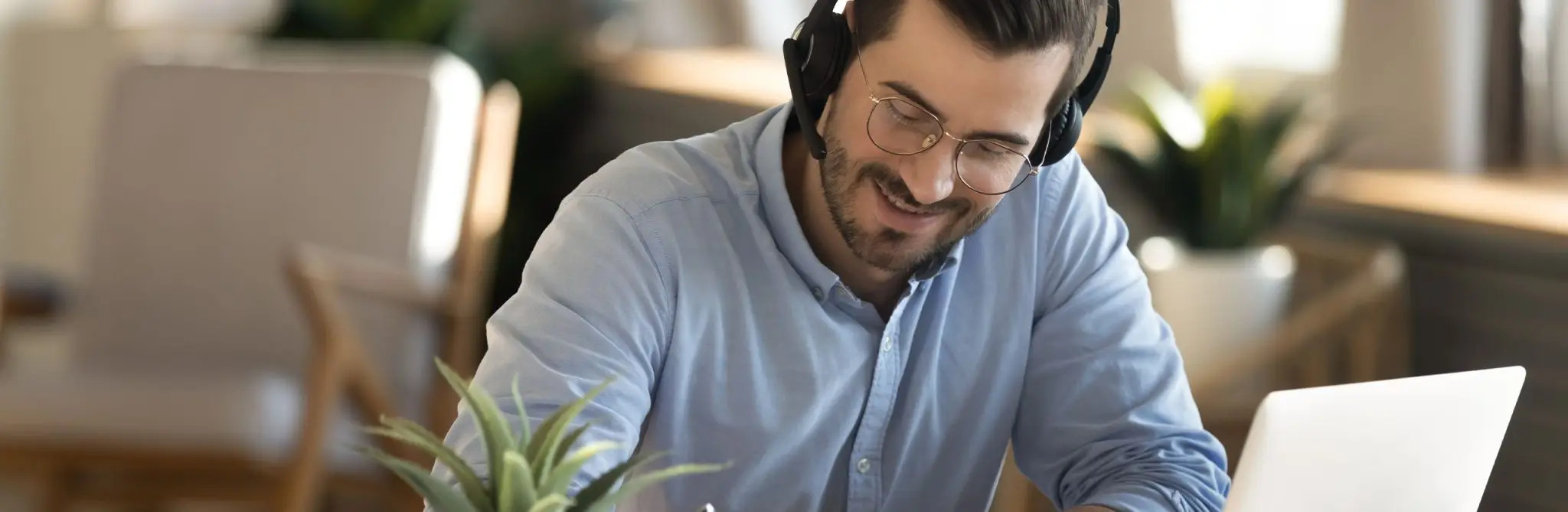 Mann med hodetelefoner som tar et nettkurs på PC